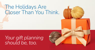 Gift box surrounded by autumn leaves representing early corporate holiday gift planning