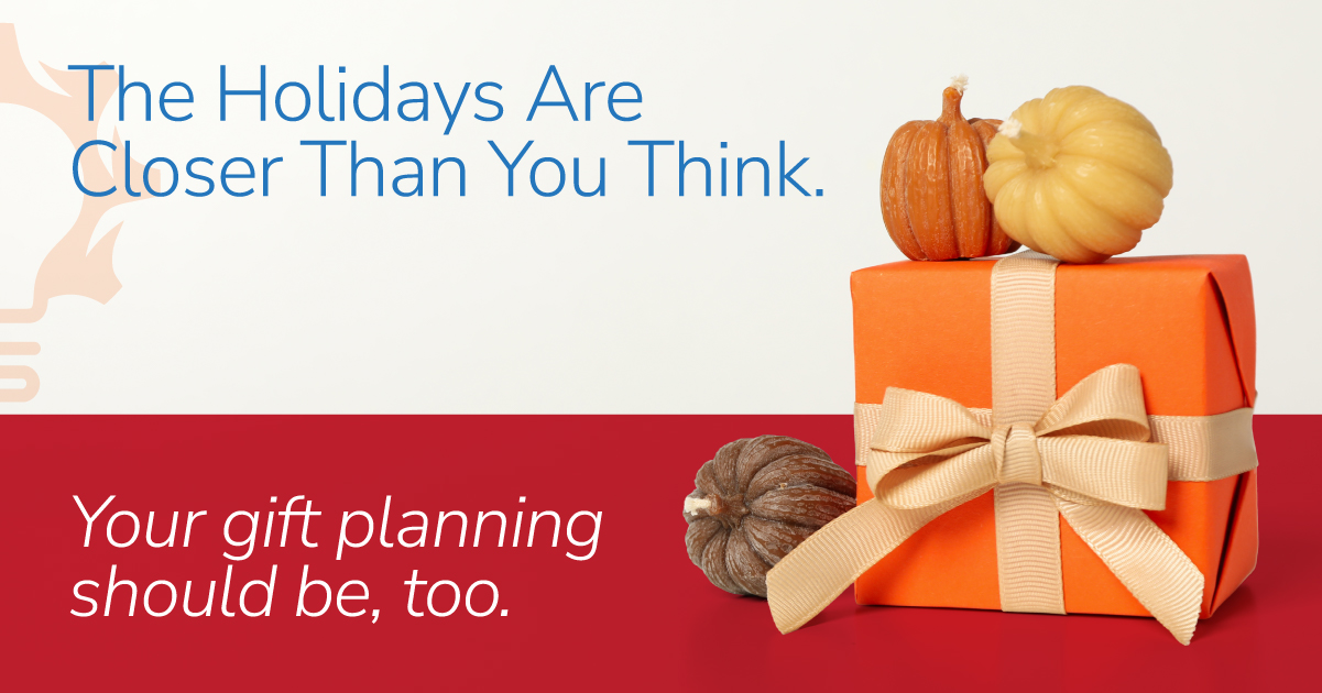 Gift box surrounded by autumn leaves representing early corporate holiday gift planning